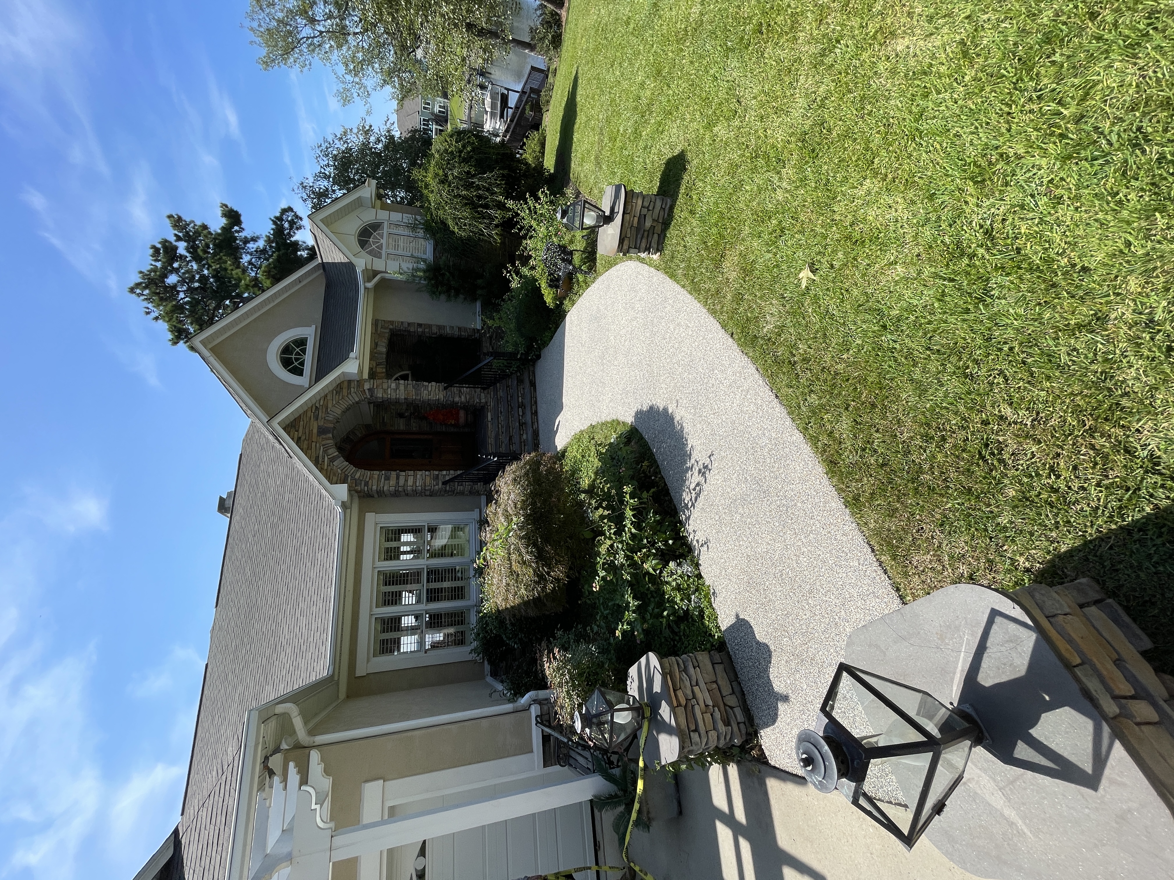 Curved resin rock driveway leading to lakefront home entrance