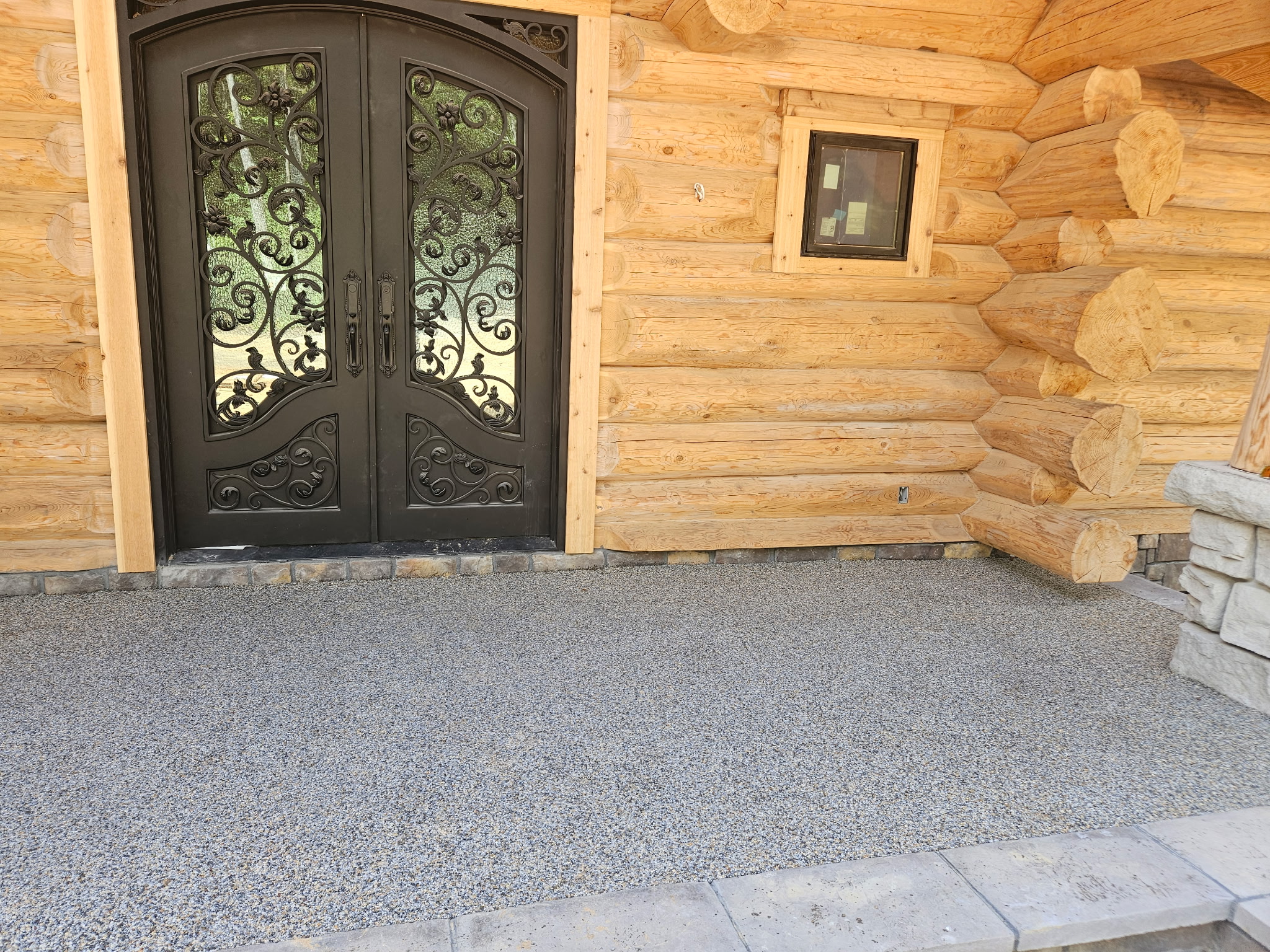 Resin rock surface at entrance of custom log cabin home