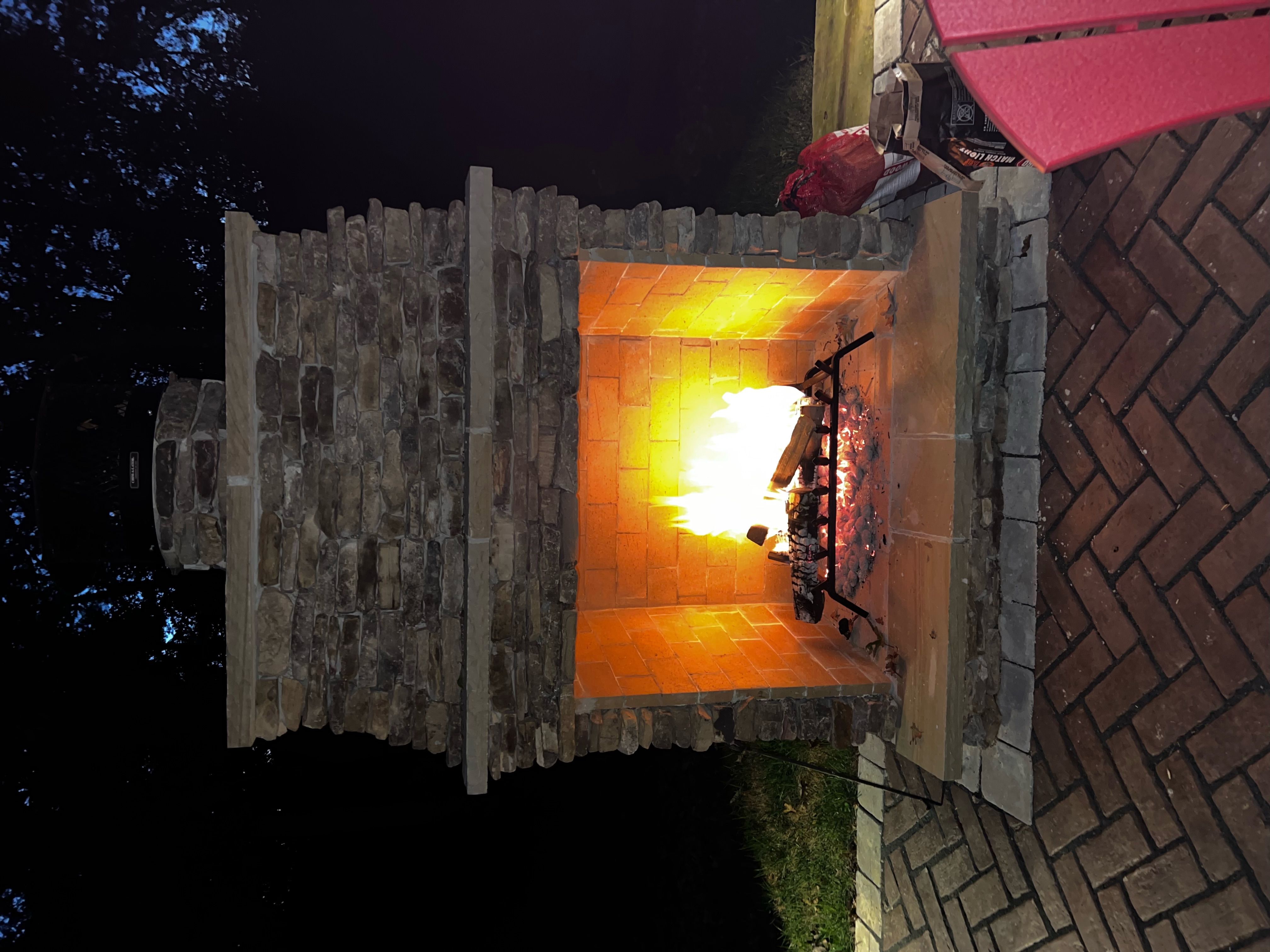 Stone outdoor fireplace with brick patio