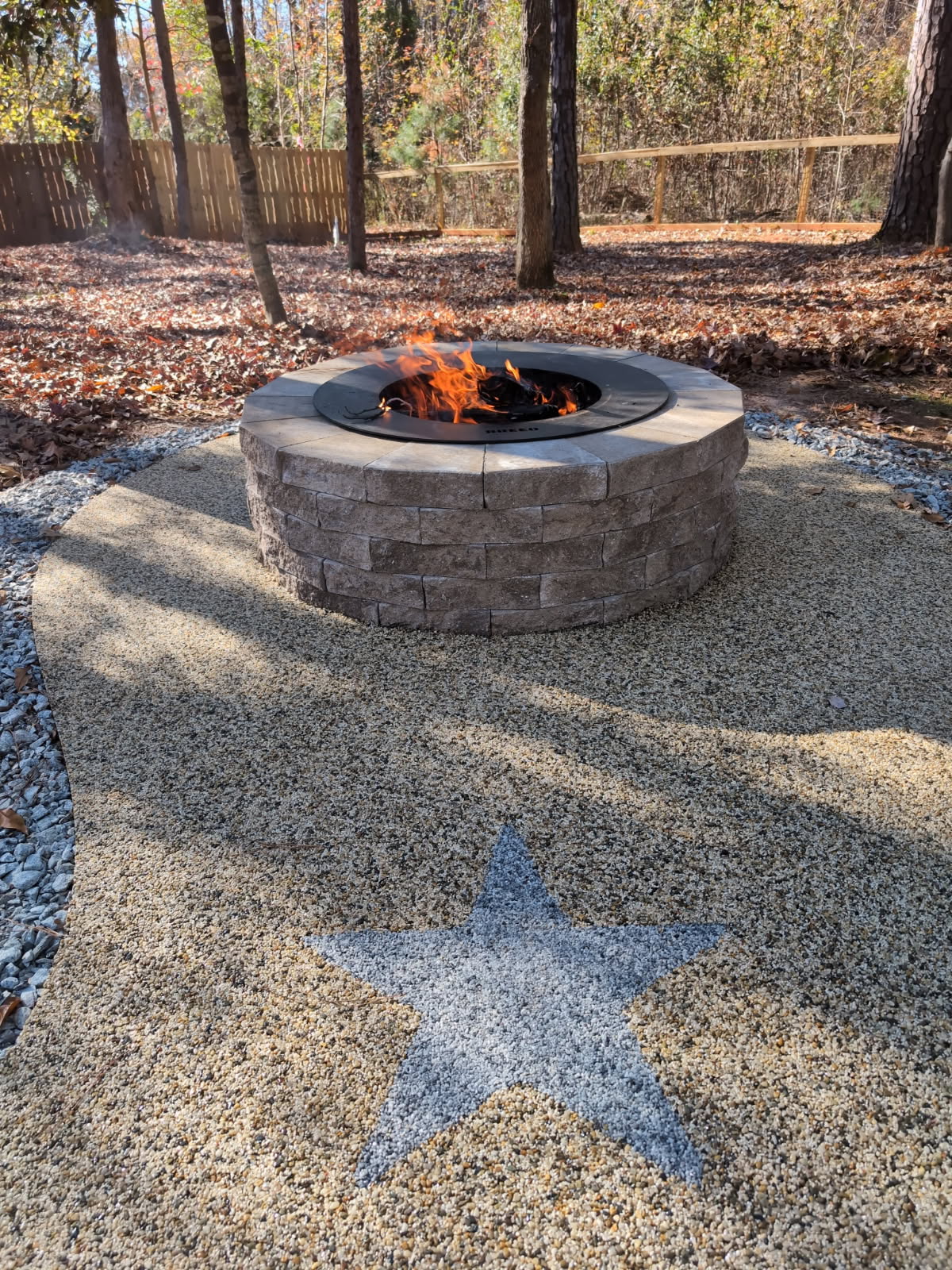 Resin rock patio with stone fire pit and star inlay design