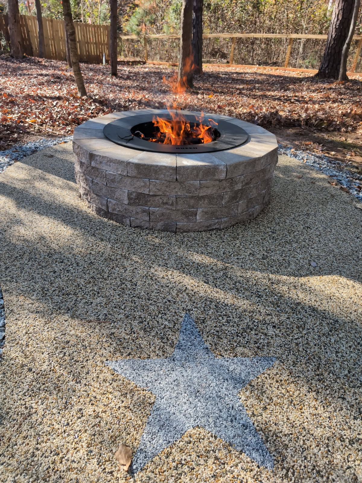 Custom stone fire pit with decorative resin rock surround