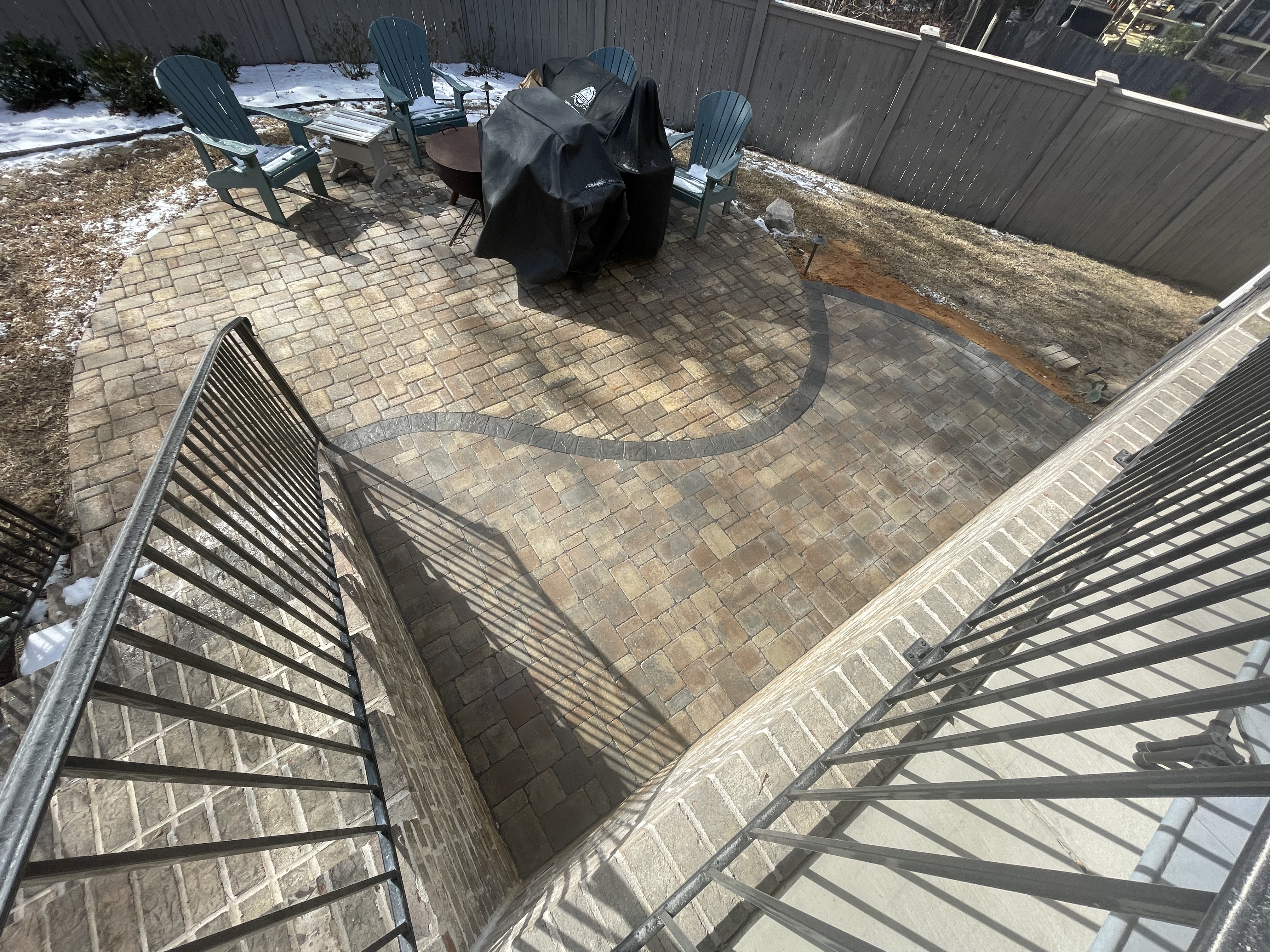 Elevated paver patio with curved decorative border and outdoor seating area