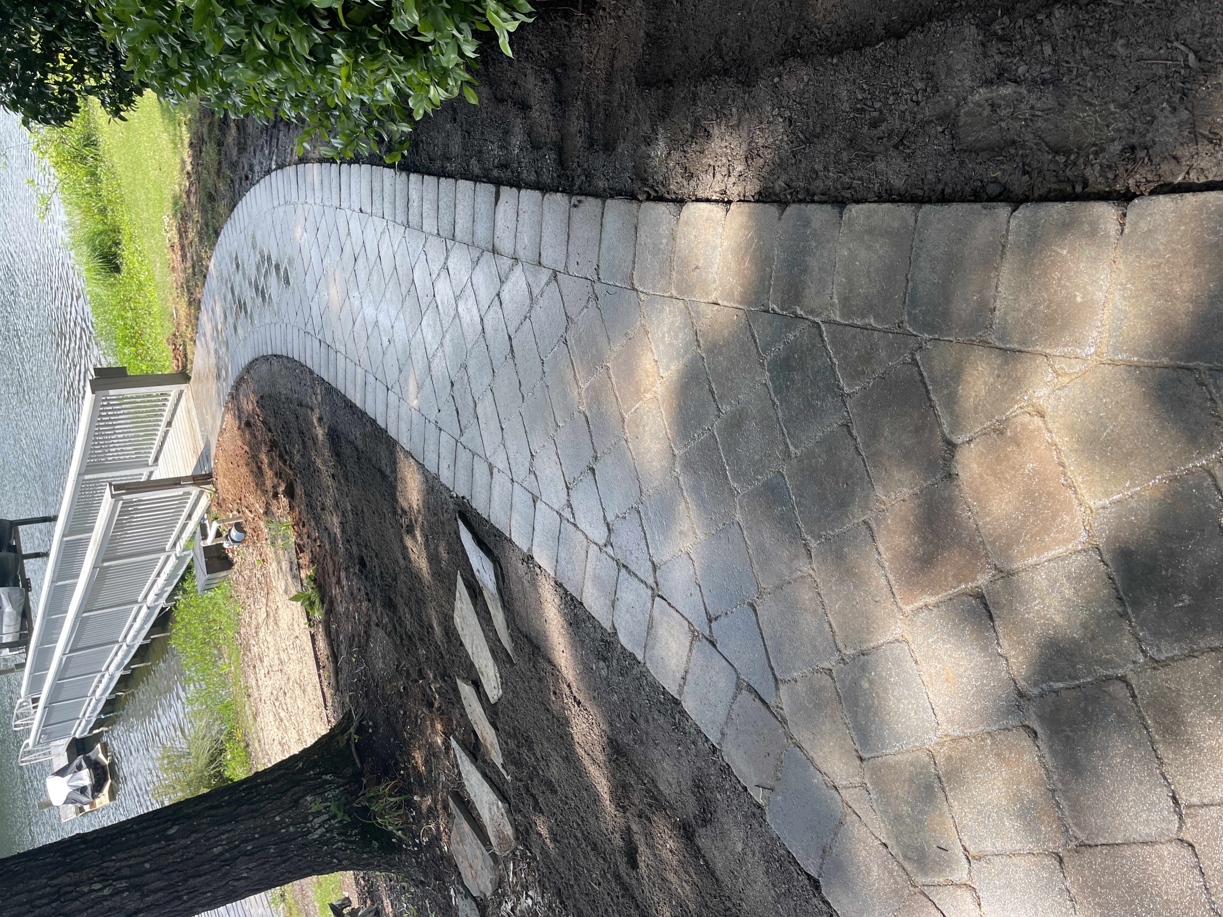 Curved cobblestone paver walkway along lakefront property