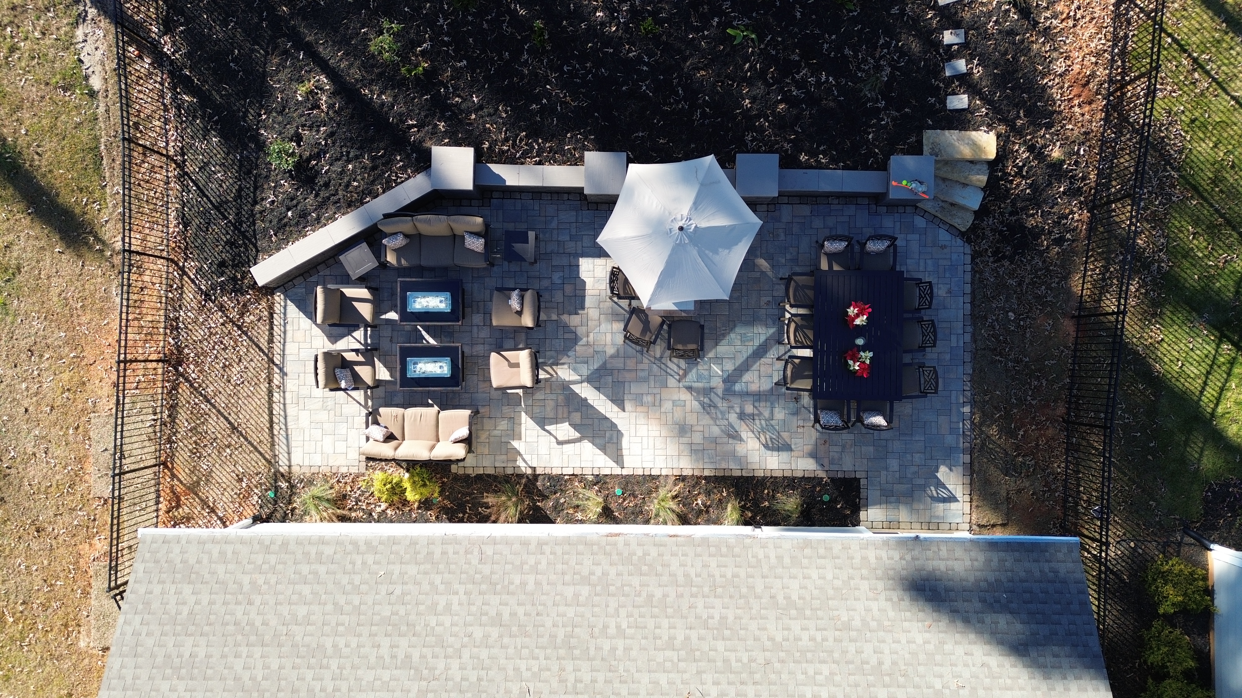 Aerial drone view of paver patio with outdoor living and dining area